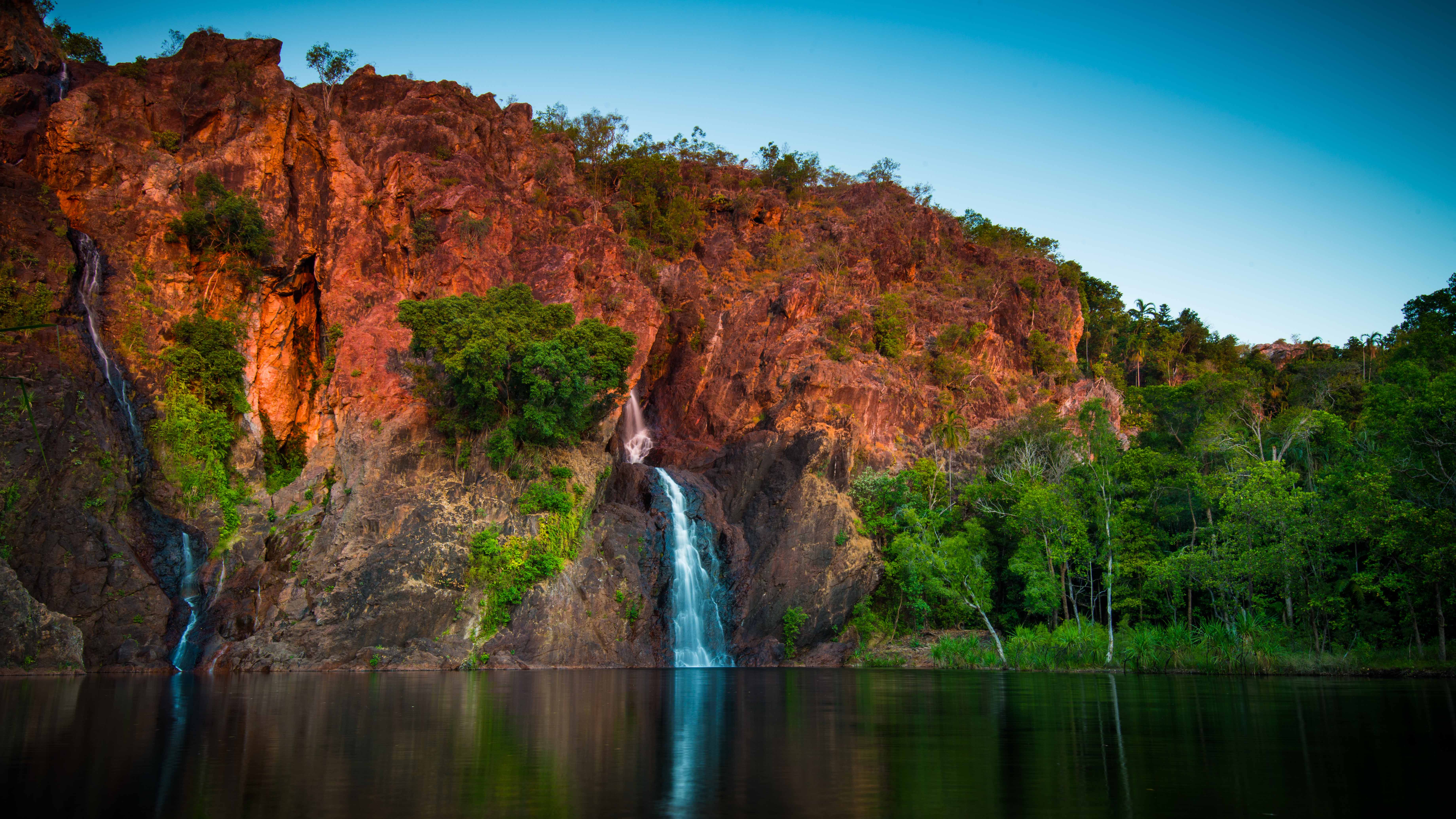 a small waterfall down red cliffs